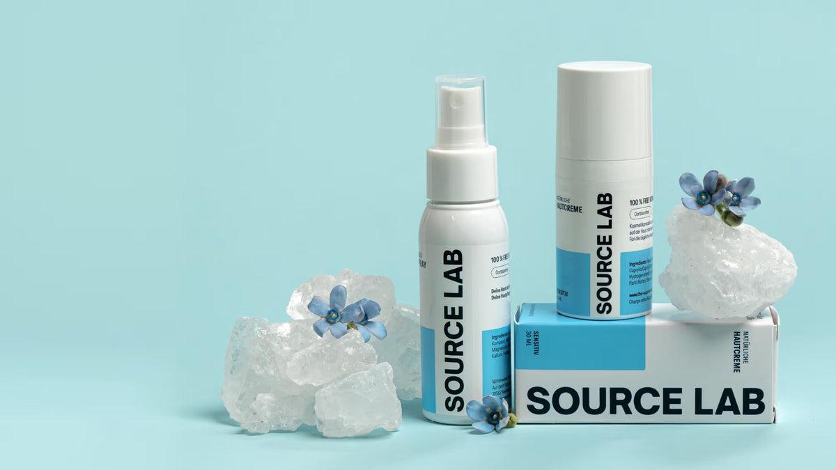 SOURCE LAB Pflegeset mit Hautspray, Hautcreme und Seife auf hellen Kristallen